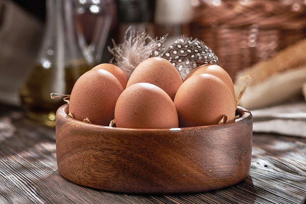 Photo brown chicken eggs close-up in a wooden bowl