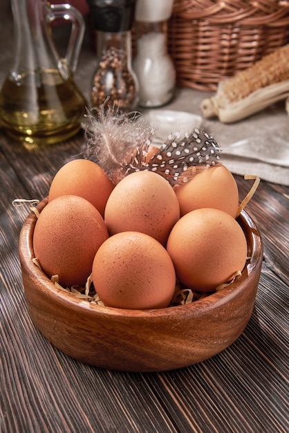 Brown chicken eggs close-up in a wooden bowl