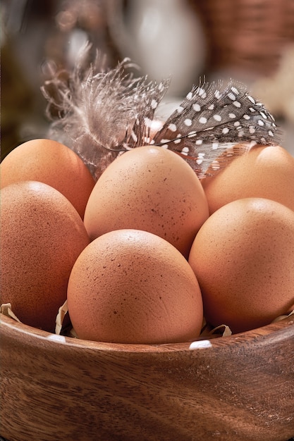 Photo brown chicken eggs close-up in a wooden bowl