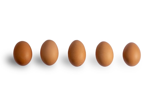 Коричневые куриные яйца на изолированной белой предпосылке с путем клиппирования. Сырые яйца. Свежие натуральные яйца.