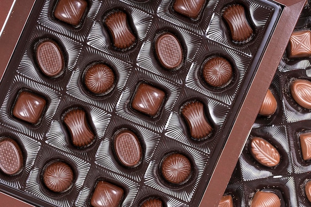 Brown chocolate candy background assortment of chocolate\
candies sweets in the box