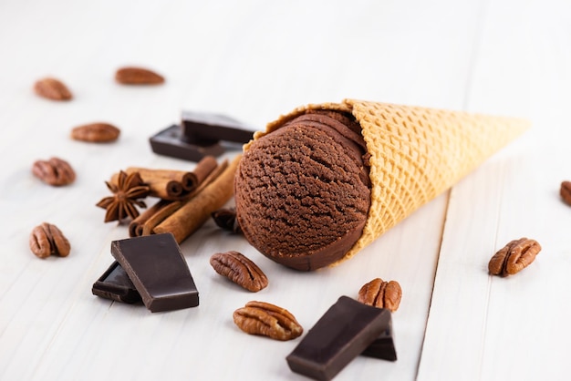 Brown chocolate ice cream with spices and pecans on a wooden background