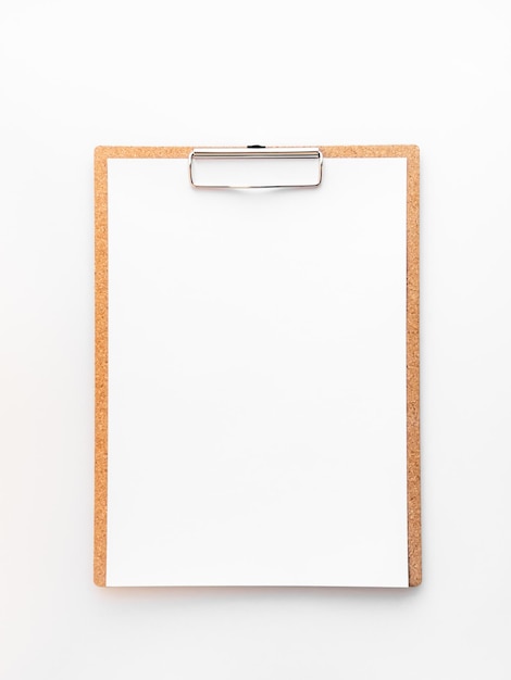 brown clipboard with a blank white sheet on a white table. empty space for text