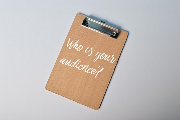 質問が書かれた茶色のクリップボード WHO IS YOUR AUDIENCE