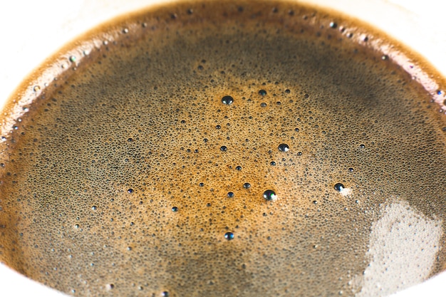 Текстура пены кофе коричневого цвета в чашке, конце вверх, фото макроса.