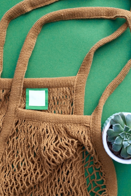 Brown color mesh eco bag on green 