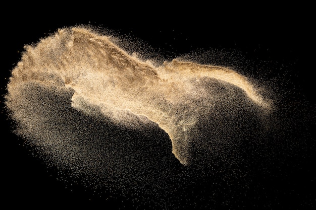 Brown colored sand splash.Dry river sand explosion isolated on black background. Abstract sand cloud.