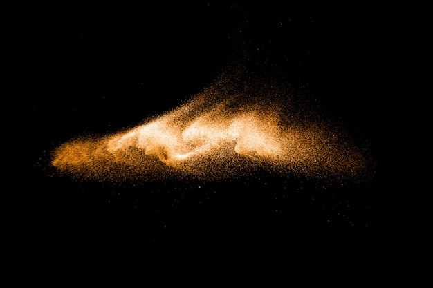 Brown colored sand splash.Dry river sand explosion isolated on black background. Abstract sand cloud.