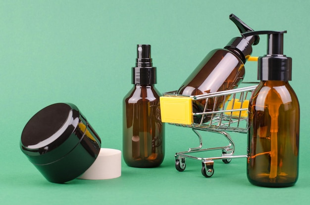 Foto bottiglie cosmetiche marroni su sfondo verde messa a fuoco selettiva concetto di shopping online per prodotti cosmetici