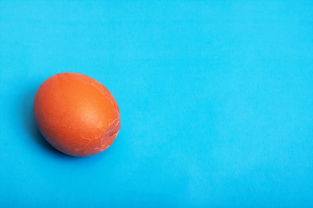 Brown cracked egg on a blue background