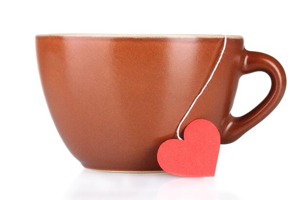 Brown cup and tea bag with red heart-shaped label on white