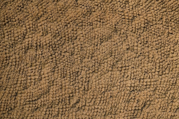 茶色と暗い砂の壁紙のファサードの古い古代の壁のレトロな背景を使用