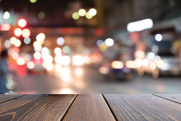 茶色の机の前にぼやけているカラフルな交通渋滞