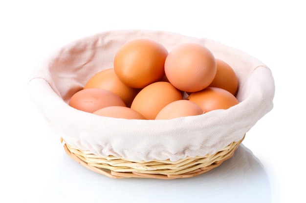 Brown eggs in basket isolated on white