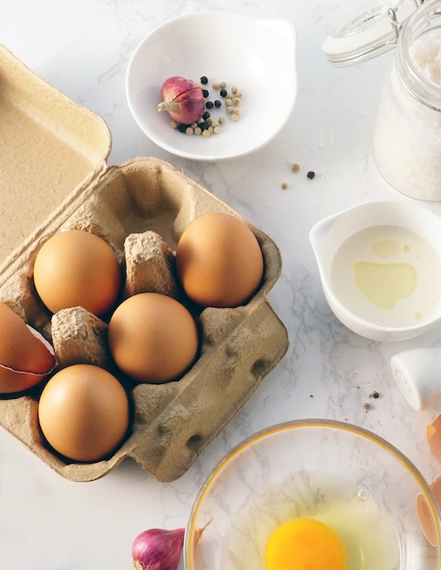 Photo brown eggs in a egg box with cooking ingredients