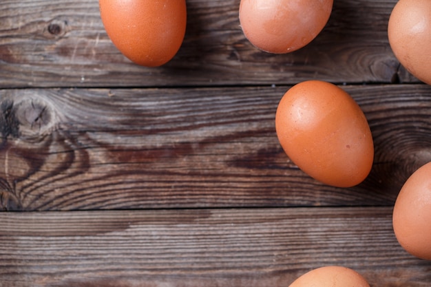 Brown eggs on a rustic wooden table.