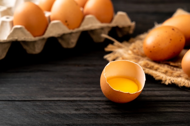 Brown eggs with one broken and egg yolk