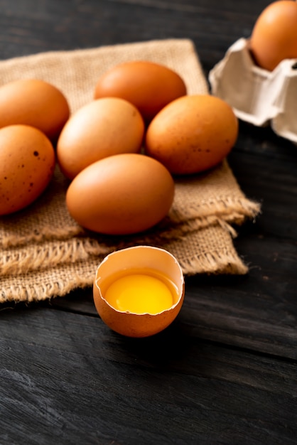 Brown eggs with one broken and egg yolk