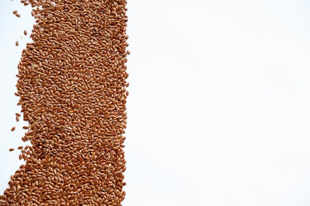 Brown flax seeds on a white background
