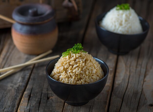 Brown fried rice served in a dish isolated on wooden board side\
view