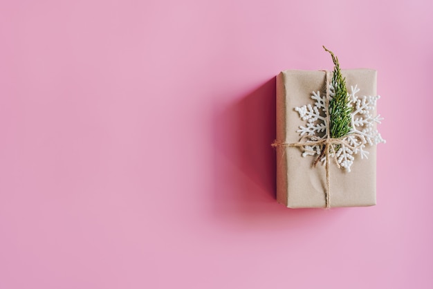 Brown gift box on the pink background. Minimal styled holiday card with copy space.