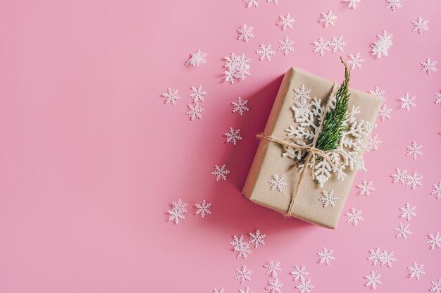 Brown gift box on the pink background with christmas decoration. 