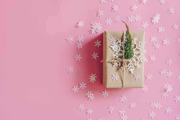 Brown gift box on the pink background with christmas decoration