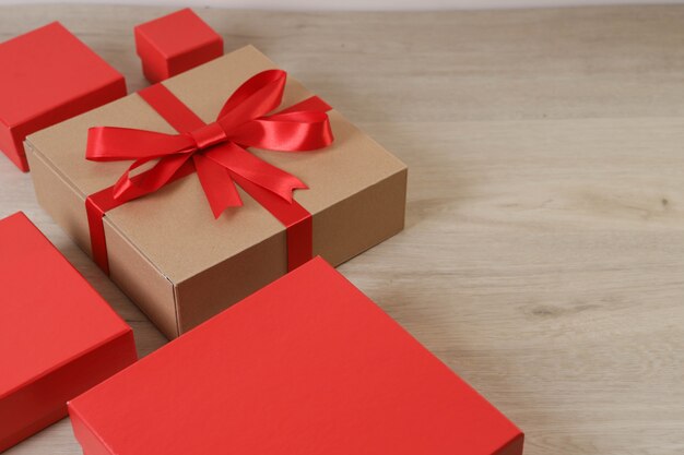 Brown gift box and red ribbon on wooden table