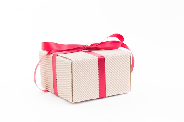 Brown gift box with red ribbon on white