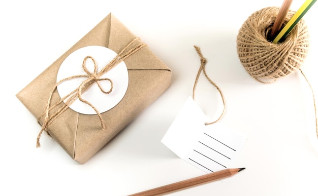 Photo brown gift box wrapped in kraft paper and rustic hemp cord spool as natural rustic style