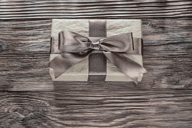 Brown gift boxes with tied bow on vintage wooden board