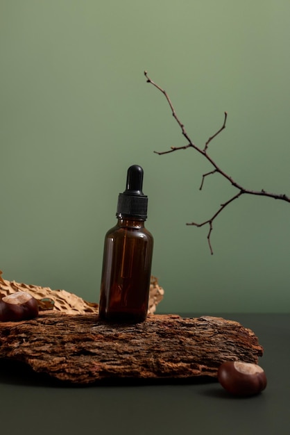 Brown glass bottle of cosmetic product or oil on wood and paper on green background natura spa cosme...