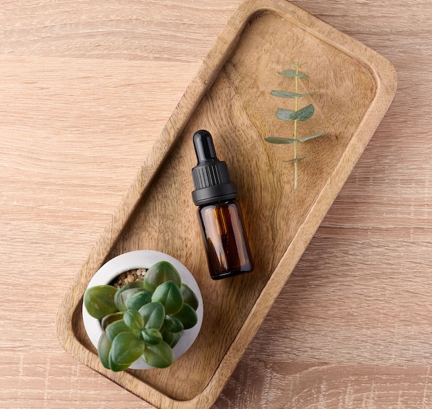 Brown glass bottle with a pipette on a wooden stand