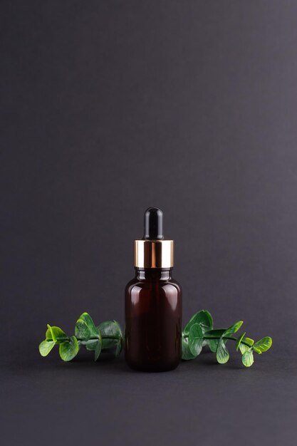 brown glass dropper bottle with a pippette with golden rubber tip on the beautiful eucalyptus