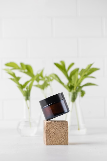 A brown glass jar of cosmetics levitates above a wooden podium