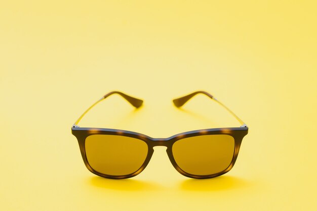 Brown glasses on yellow background