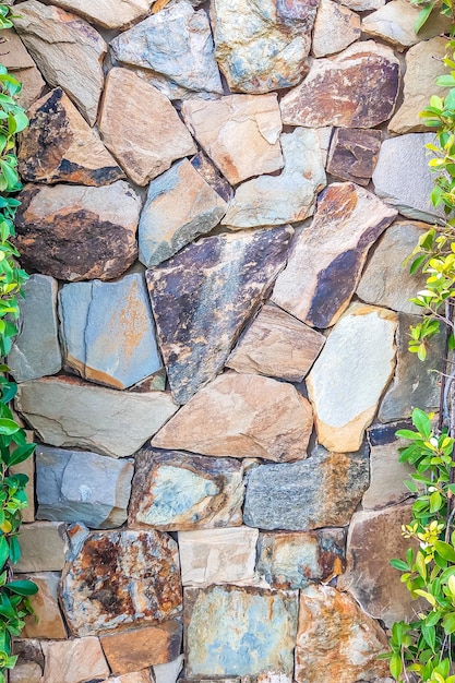 Brown gray stone wall with green leaves on both sides Background Stories vertical format