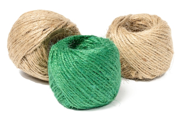 Photo brown and green skeins of jute rope on a white isolated background