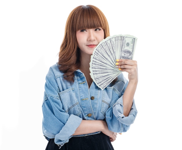 Brown hair Asian woman holding and feel happy with American banknotes that spread out in her hand, she smiling, studio shot on white background.