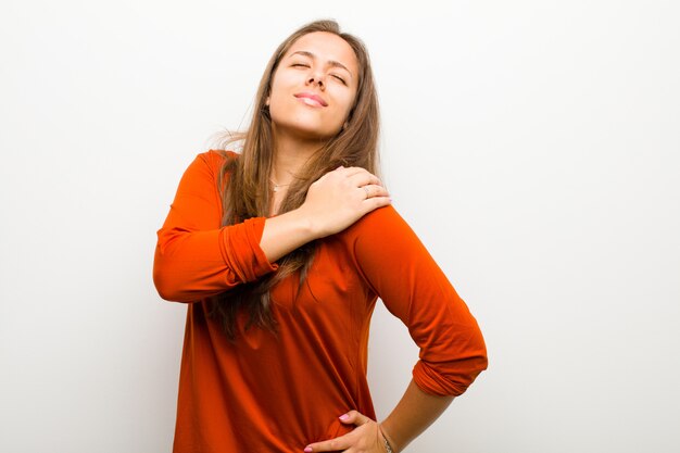 brown haired girl holding her painful shoulder