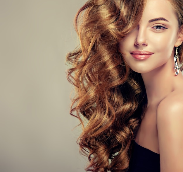 Brown haired woman with elegant voluminous and frizzy hairstyle.