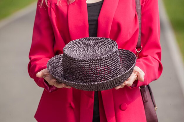 Cappello fatto a mano marrone nelle mani di una ragazza