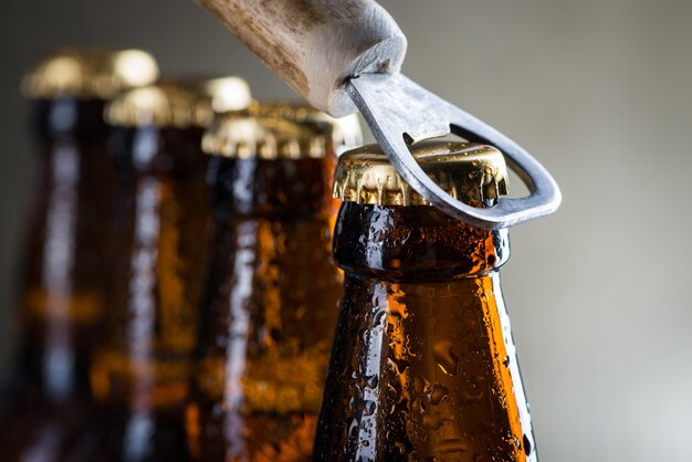 Foto bottiglie di birra ghiacciate marroni con il vecchio apriscatole