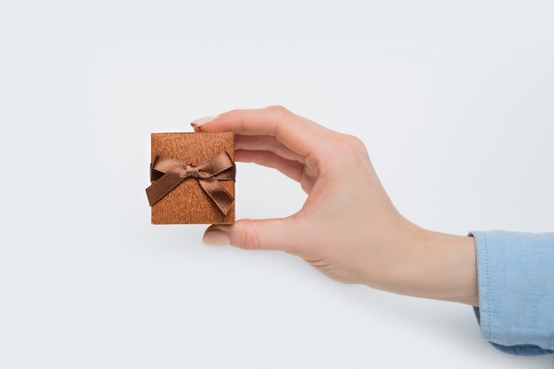 Brown jewelry box in female hand. 