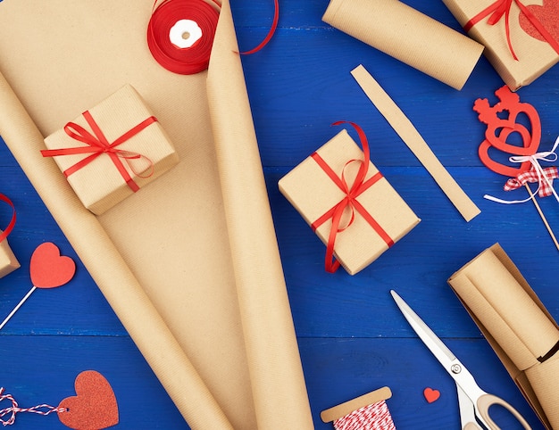 Brown kraft paper, packed gift bags and tied with a red ribbon, red heart, set of items for making gifts