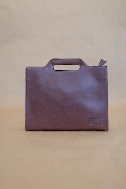 Foto borsa in pelle marrone su sfondo beige