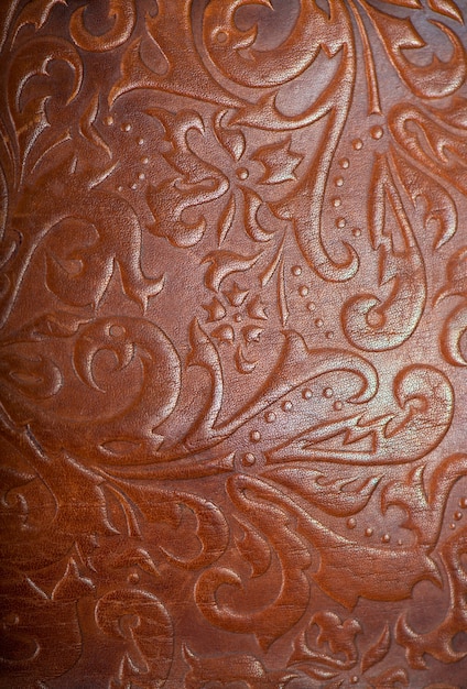 Brown leather book or journal cover with a decorative floral ornament.