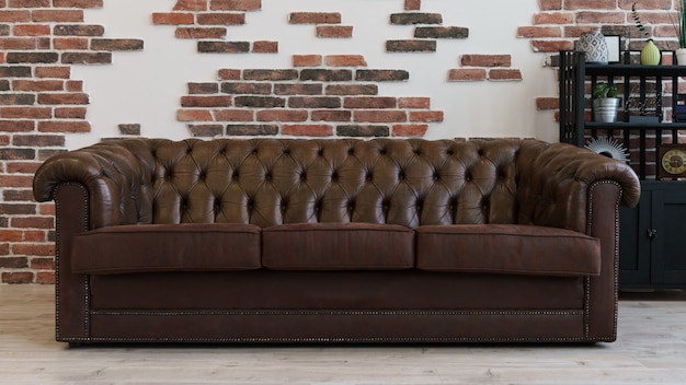 Brown leather couch in loft style room and brick wall