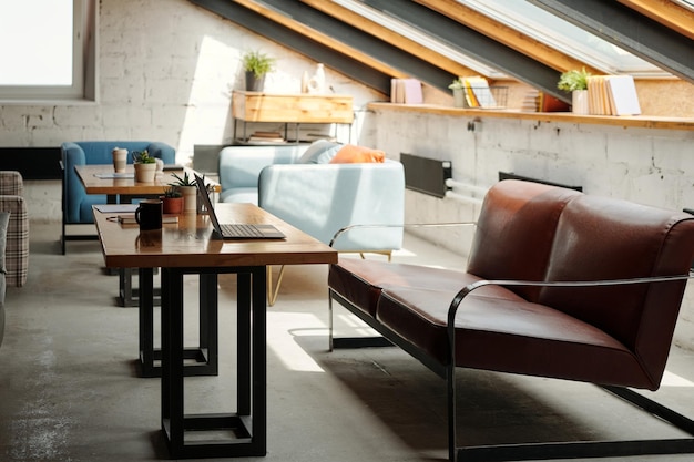 Brown leather couch standing in front of workplace of white collar worker