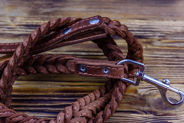 Brown leather dog leash on a wooden background